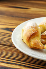 Homemade fresh bagels in white plate on wooden background.