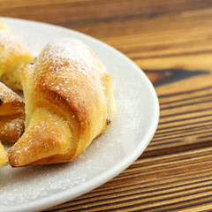 Homemade fresh bagels in white plate on wooden background.