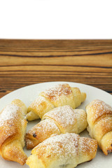 Homemade fresh bagels in plate on wooden and white background.