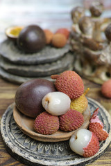 Lychees and Passion Fruit or Maracuya on wooden background - exotic fruits