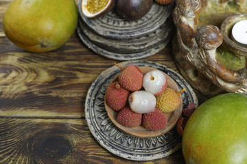 Lychees on wooden background - exotic and tropical fruit