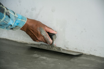 plasterer concrete worker at floor of house construction