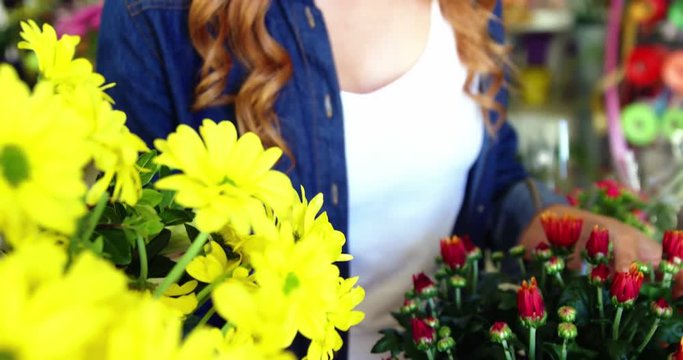 Beautiful female florist arraigning flower bouquet in flower shop