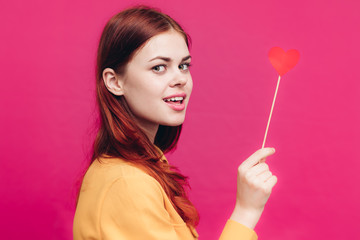 attractive woman holding a heart with a stick in her hand