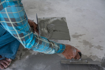 plasterer concrete worker at floor of house construction