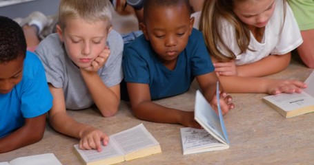 School kids reading book in library at school 4k - Powered by Adobe