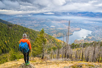 Fototapeta premium A female hiker admires the view of Holland Lake in Montana