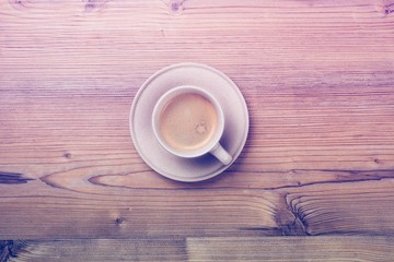 Cup of coffee on wooden vintage board background