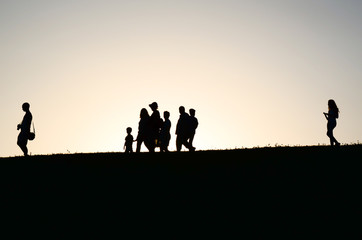 Fototapeta na wymiar Silhoettes of people walking in the sunset 