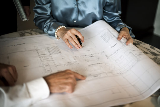 People working on architectural blueprint.