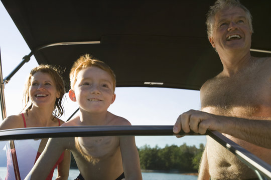 Young boy and his mature grandparents on a boat.