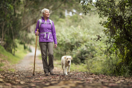 Mature woman on a rural hike with her dog.