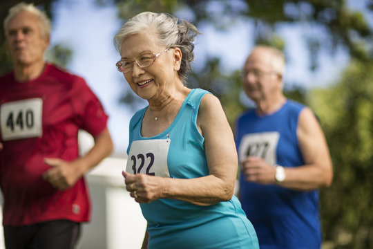 Elderly woman has fun running in a race at an athletics event.