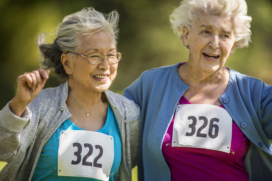 Two elderly friends have fun at an athletics event.