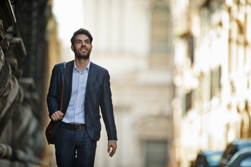 Portrait of a smiling young businessman walking to work in the city.