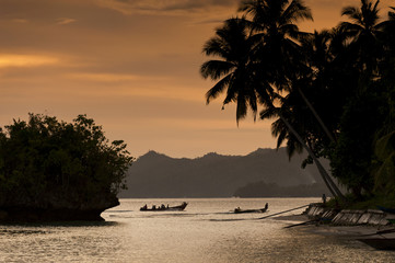Waigeo Island, Raja Ampat, Indonesia. This remote tropical island village called Saporkren is rarely visited by tourists. Sunset is the time for villagers to have fun in the water and enjoy nature. © LoweStock