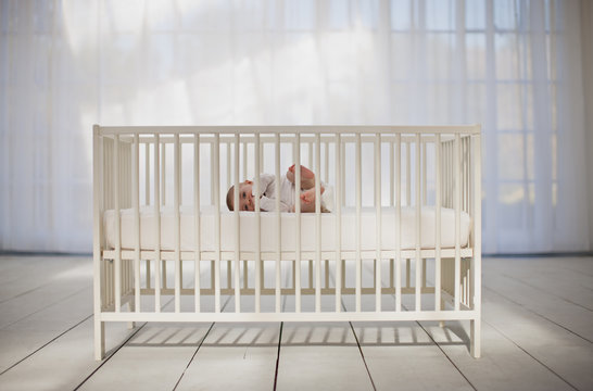 Baby boy laying in crib
