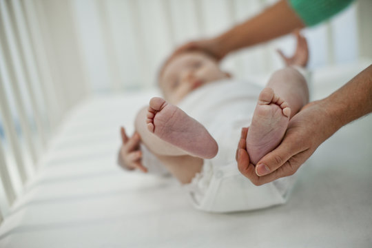 Young mother keeping her son in cot 