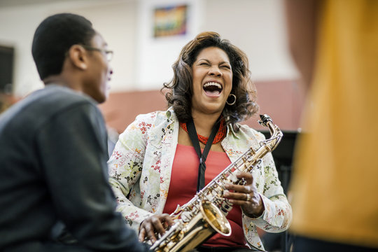 Smiling teacher holding trumpet in classroom