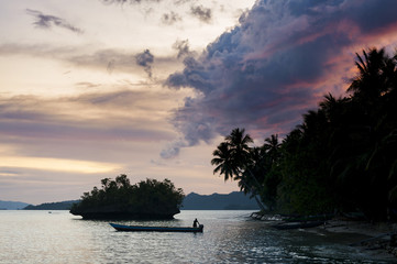 Fototapeta na wymiar Waigeo Island, Raja Ampat, Indonesia. This remote tropical island village called Saporkren is rarely visited by tourists. Sunset is the time for villagers to have fun in the water and enjoy nature.