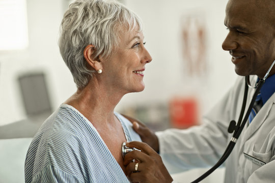 Cheerful mature woman gets her heartbeat checked by a friendly doctor.