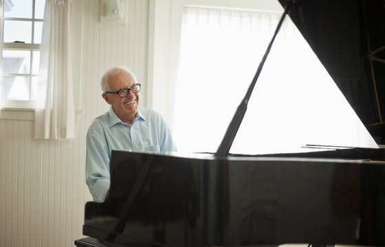 Portrait of a happy senior man playing the piano.