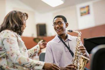 Young man being instructed by music teacher.