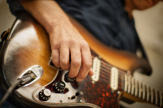 Mature adult man playing an electric guitar.