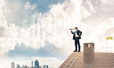 Engineer man standing on roof and looking in spyglass. Mixed med