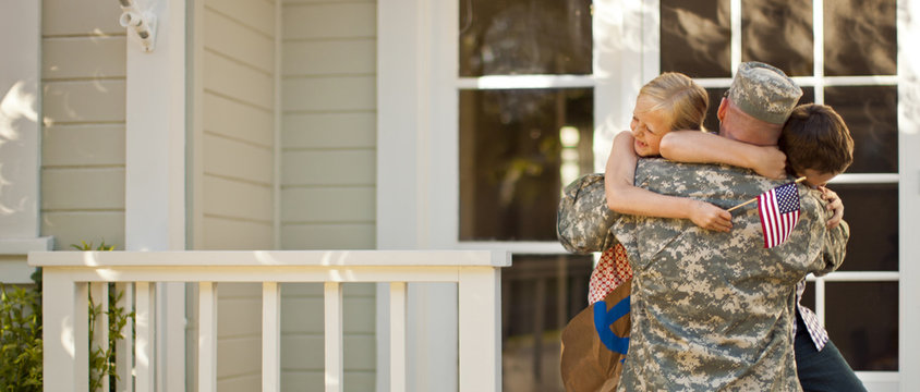 Army soldier hugging his children