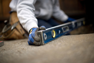 Gloved hands holding a level