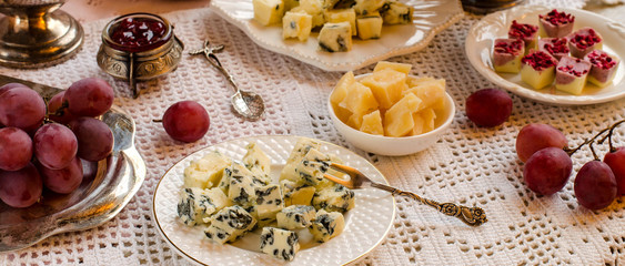A beautiful table setting with cheeses and desserts.