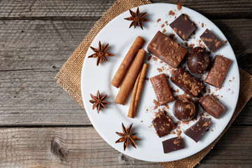 Pieces of chocolate with cinnamon and star anise on table