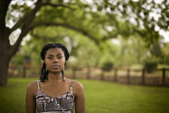 Portrait of a serious young woman in a field.