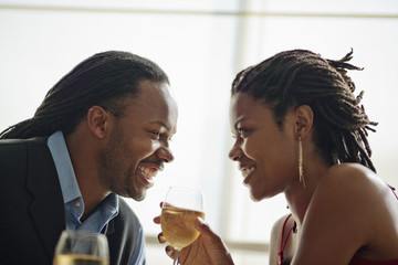 Happy young couple gazing into each other's eyes as they enjoy a romantic dinner.