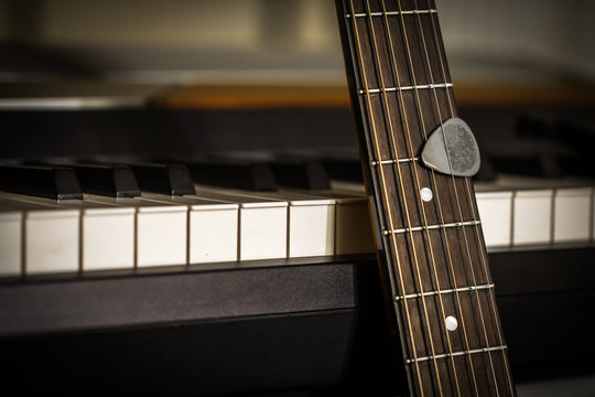 musical instruments piano keys and acoustic guitar with plectrum