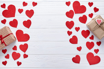 Red hearts and gift boxs on a white wooden background. Flat lay. Romantic background to St. Valentine's Day, a date loving couple. Symbol of love.