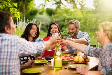 Group of friends toasting during a party on a terrace in summer