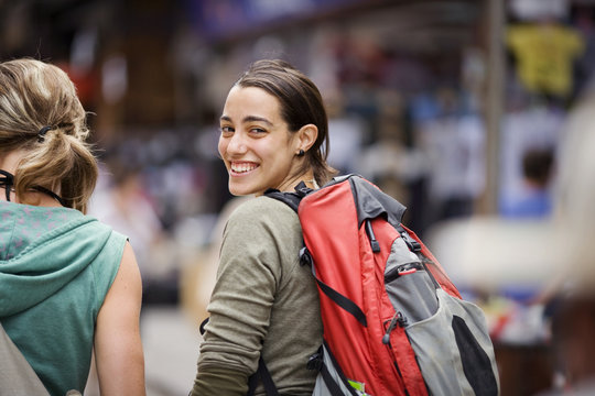 Portrait of a young adult girl walking in a city.