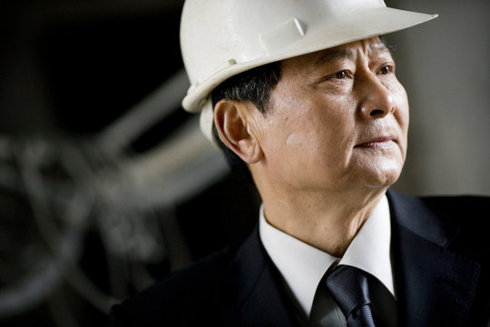 Mature adult businessman wearing a hard hat.