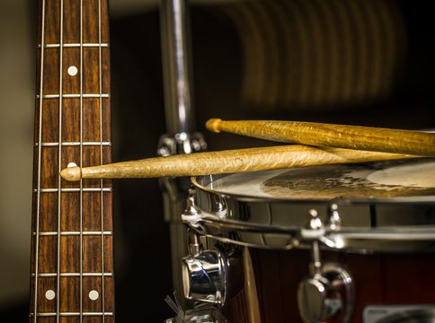 snare drum with drumsticks and bass guitar