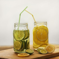 On the Board two cans of soda. Drinks - lemon and lime. Diffused light. Slices of citrus in a jar on the table. Lifestyle. White background.