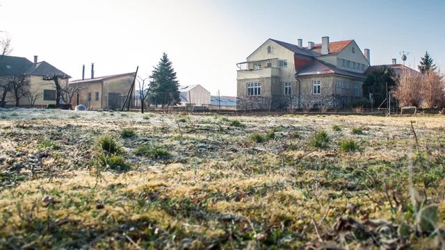 Moving timelapse of frosted grass and villa
