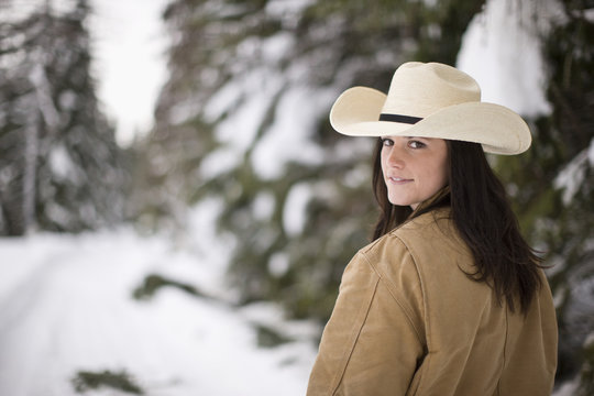 Portrait of young woman in cowboy hat standing outdoors