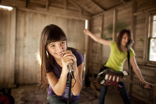 Two teenage girls having fun at band practice.