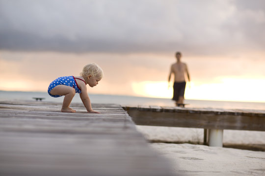 Baby crawling on pier.