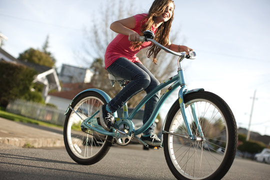 Teenage girl cycling along the street on her bike.
