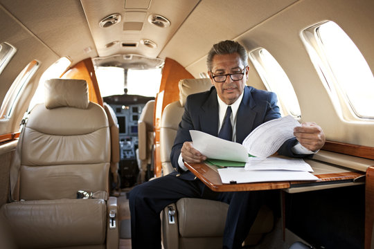 Businessman reading some documents on a private jet