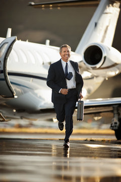A businessman running from a plane at the airport