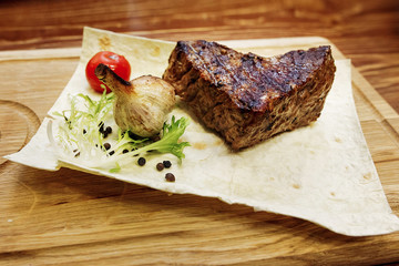 juicy meat grilled steak with red pepper tomato and garlic. serv